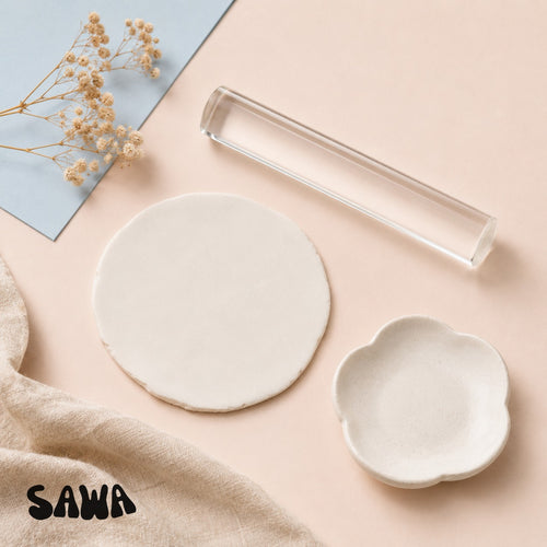 Hands rolling out a slab of white air-dry clay with the Sawa clear acrylic clay roller