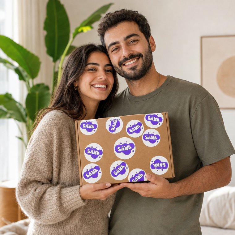 A couple holding a Sawa pottery kit box together and smiling